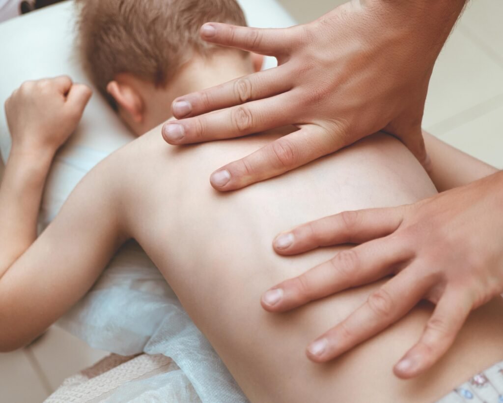Osteopatia pediatrica a Carmagnola: trattamento manuale sulla schiena di un bambino